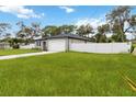 A beautiful, modern home with a two-car garage, white fence and a well-manicured lawn at 2341 Oleander Rd, Deland, FL 32724