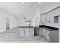 Bright kitchen boasts grey cabinets, black countertops, and an open layout into the living area at 23741 Sw Blueberry Ln, Dunnellon, FL 34431