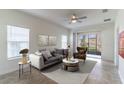 Bright living room with a ceiling fan, neutral tones, plush sofa, and sliding glass doors to the patio at 2833 Attwater Loop, Winter Haven, FL 33884