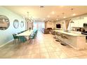 Open-concept design of the living room, dining area, and kitchen with tile floors and recessed lighting at 3044 Mahalo Dr, Davenport, FL 33897