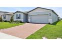 Well-maintained single-story home with brick driveway, two-car garage, and green lawn at 4544 Windy Oak Way, St Cloud, FL 34772