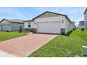 Charming single-story home with a brick driveway, two-car garage, and well-manicured lawn at 4550 Windy Oak Way, St Cloud, FL 34772