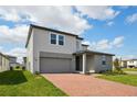 Beautiful two-story house featuring a brick driveway, two-car garage, and a well-maintained lawn at 4556 Windy Oak Way, St Cloud, FL 34772