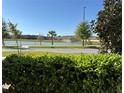 Scenic view of a pond framed by lush greenery and a clear blue sky at 5059 Lake Hamlin Trl, Winter Garden, FL 34787