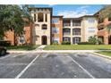 A condominium building boasting multiple stories, neutral-colored exteriors, balconies, and manicured lawn at 5512 Metrowest Blvd # 203, Orlando, FL 32811