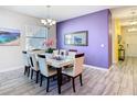 Elegant dining room showcasing a modern chandelier, large window, and seating for six at 5528 Solterra Cir, Davenport, FL 33837