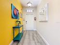 Bright entryway featuring decorative walls, tiled floors, and a stylish console table at 5528 Solterra Cir, Davenport, FL 33837