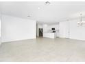 Bright living space featuring neutral tile floors, an elegant chandelier, and an open concept design at 5733 Iron Brand Rd, St Cloud, FL 34771