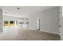 Open concept living space with modern lighting and a view to the kitchen and back yard at 6084 Sw 150Th Ln, Ocala, FL 34473