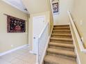 Carpeted staircase with white railing and neutral paint at 7407 Excitement Dr, Reunion, FL 34747