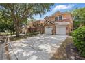 View of a stucco townhome featuring a stone facade, a tile roof, and a two-car garage at 7620 Bay Port Rd # 39, Orlando, FL 32819