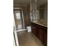 Modern bathroom with tiled shower, dark wood vanity, and tile flooring at 8521 Vedder Ln, Orlando, FL 32832