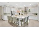 Bright kitchen with stainless steel appliances, a large island, white cabinets, and an elegant tile backsplash at 9888 Mere Pkwy, Orlando, FL 32832