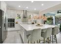 Bright kitchen with stainless steel appliances, a large island, white cabinets, and an elegant tile backsplash at 9888 Mere Pkwy, Orlando, FL 32832