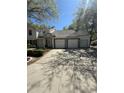 Condo exterior featuring multiple garages, stone accents, and a well-maintained driveway at 1010 Loch Vail # 1125, Apopka, FL 32712