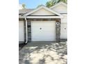 Garage exterior with a white door, stone accents and an exterior lamp at 1010 Loch Vail # 1125, Apopka, FL 32712