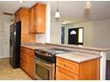 Modern kitchen with stainless steel stove, granite counters, wood cabinets at 122 W Hillcrest St, Altamonte Springs, FL 32714
