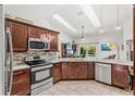 Updated kitchen features modern stainless appliances and a tile backsplash at 12712 Forestedge Cir, Orlando, FL 32828