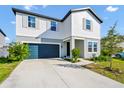 Charming two-story home with a blue garage door, landscaped yard, and a combination of white and gray siding at 2126 Derwent Dr, Davenport, FL 33896
