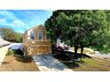 Two-story home with a tan exterior, attached garage, and a long driveway at 25012 Chipshot Ct, Sorrento, FL 32776