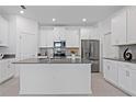 Bright kitchen featuring white cabinetry, stainless steel appliances, and gray countertops at 2750 Slash Way, St Cloud, FL 34771