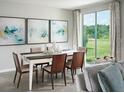 Elegant dining room with view, featuring a stylish table, seating for six, and contemporary artwork at 305 Castle Dr, Lake Alfred, FL 33850