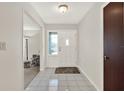 Bright foyer featuring tiled floors, a front door with sidelight, and a glimpse into the living area at 31024 Prestwick Ave, Sorrento, FL 32776