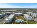 Aerial view of condo community featuring a pool, landscaping, and spacious parking and manicured landscaping at 3121 Paradox Cir # 307, Kissimmee, FL 34746