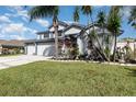 Charming two-story home featuring lush tropical landscaping and well-maintained green lawn at 3244 Amaca Cir, Orlando, FL 32837