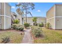 Exterior view of lush condominium courtyard featuring manicured shrubbery, grassy areas, and walkways at 336 Scottsdale Sq # 336, Winter Park, FL 32792