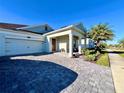 Well-maintained one-story home featuring a two-car garage, brick-paved driveway, and inviting entrance at 4562 Tribute Trl, Kissimmee, FL 34746