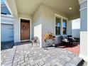 Inviting covered front porch with stylish seating, a decorative bicycle planter, and a welcoming entrance at 4562 Tribute Trl, Kissimmee, FL 34746