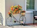 Close-up of a decorative bicycle planter filled with vibrant flowers on the front porch at 4562 Tribute Trl, Kissimmee, FL 34746
