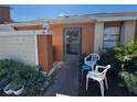 Close up of the front door with orange stucco, cream siding, and chairs outside at 46 Silver Park Cir, Kissimmee, FL 34743