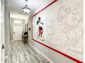 Welcoming hallway with a Mickey Mouse mural and decorated console table at 4704 Sleepy Hollow Dr, Kissimmee, FL 34746