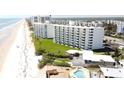 Stunning aerial view of beach condos, showcasing landscaping, and a community pool for relaxed coastal living at 5201 S Atlantic Ave # 405A, New Smyrna Beach, FL 32169