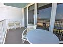 Cozy balcony features chairs and table; perfect for enjoying ocean views at 5201 S Atlantic Ave # 405A, New Smyrna Beach, FL 32169