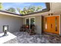 Inviting front porch with rocking chairs and a vibrant orange front door at 5370 Whispering Pine Cir, St Cloud, FL 34771
