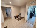 Inviting foyer with neutral tile flooring, console table, and clear view to other rooms at 5526 Bonn Way, St Cloud, FL 34771