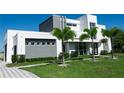 Modern two-story home with clean lines and palm trees, showcasing architectural design and manicured landscaping at 6106 Marleon Dr, Windermere, FL 34786