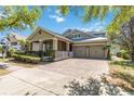 Inviting single-story home with brick driveway, well-kept lawn, and a convenient two-car garage at 6799 Helmsley Cir, Windermere, FL 34786