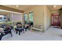 Cozy front porch featuring outdoor seating, a bench, and an inviting entrance with a red door at 6799 Helmsley Cir, Windermere, FL 34786