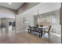Bright dining room featuring tile floors, modern light fixture, and a contemporary dining table with bench seating at 7131 Desert Mandarin St, Winter Garden, FL 34787