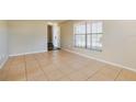 Bright living room featuring tile flooring, neutral walls, and a large window for natural light at 7355 Rush Ct, Orlando, FL 32818