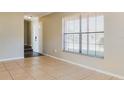 Bright living room featuring tile flooring, neutral walls, and a large window for natural light at 7355 Rush Ct, Orlando, FL 32818