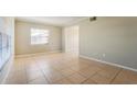 Spacious living room features tile flooring, neutral walls, and large windows for natural light at 7355 Rush Ct, Orlando, FL 32818