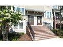 Charming townhome entrances featuring brick stairs, black railings, and well-maintained landscaping at 869 Taramundi Dr, Oviedo, FL 32765
