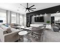 Bright living room featuring a modern entertainment center, sleek furniture and gray ceramic flooring at 1720 Sawyer Palm Pl, Kissimmee, FL 34747