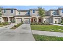 Charming townhomes with front lawns, driveways and two-story facades with neutral colors at 2087 Crystal Bell St, Orlando, FL 32824