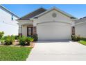 Charming single-story home showcasing a well-manicured lawn and an attached two-car garage at 2285 Canyon Breeze Ave, Kissimmee, FL 34746